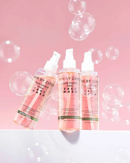 Three bottles of 'Skin by Zaron' face wash on a pink background with bubbles.