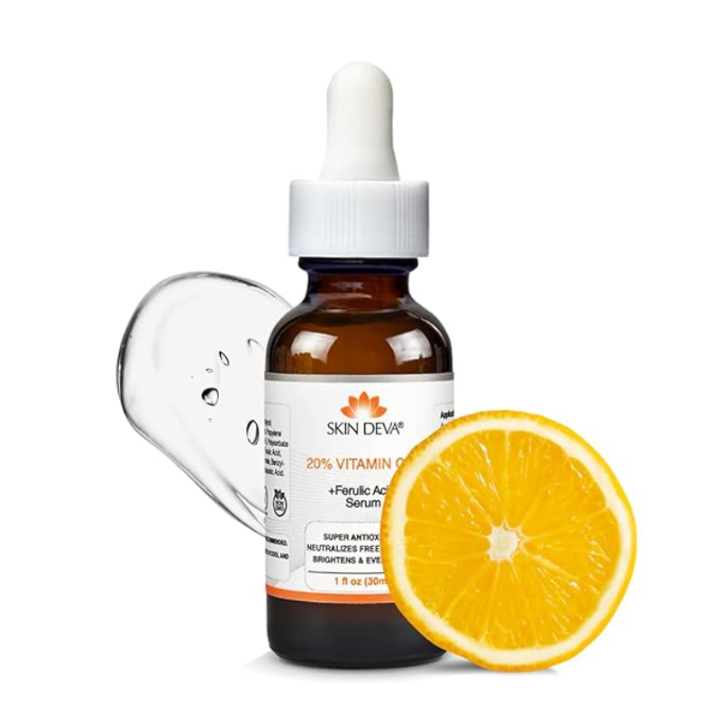 A 30ML bottle of SKIN DEVA 20% Vitamin C + E with Ferulic Acid Serum features a dropper and serum smear for antioxidant skincare. A half slice of orange beside the bottle underscores its citrus theme and highlights its efficacy in hyperpigmentation treatment.