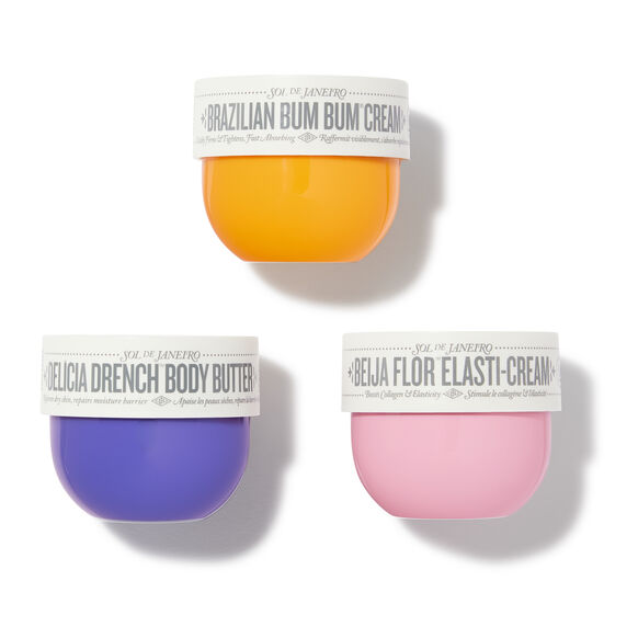 Three small containers of different colored creams on a white background
