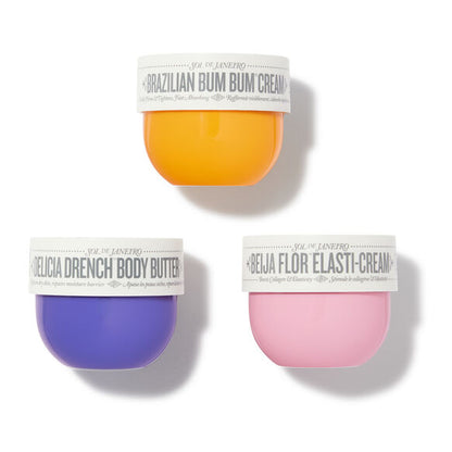 Three small containers of different colored creams on a white background