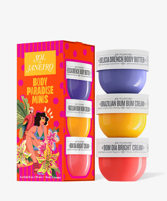 The Sol de Janeiro Body Paradise Minis Set by Sol de Janeiro features three travel-size body creams in purple, yellow, and orange jars, displayed next to a vibrant tropical-themed box—ideal for Brazilian body care on the go.