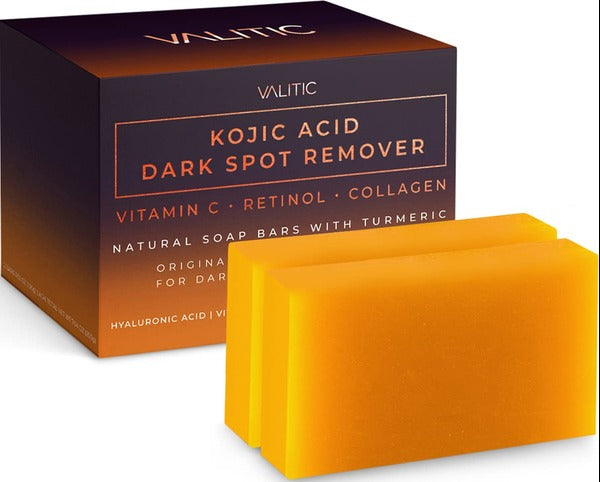 A box labeled VALITIC Kojic Acid Dark Spot Remover Soap with Retinol and Turmeric sits beside two orange rectangular soap bars. The packaging highlights Kojic Acid and natural ingredients for dark spot treatment.
