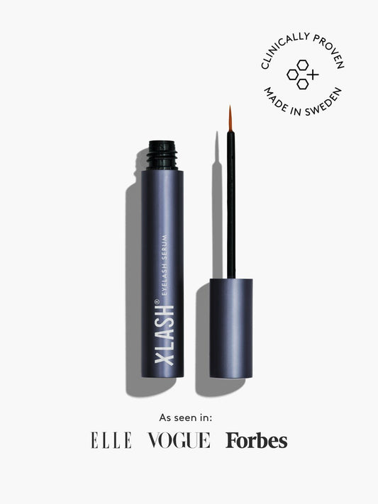 Eyelash serum with applicator on a white background, featuring ELLE, Vogue, and Forbes logos.