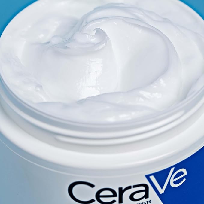 An open CeraVe Moisturizing Cream for Normal to Dry Skin with Ceramides - 454g sits against a blue background, showcasing its smoothly swirled white cream and a hint of the label.