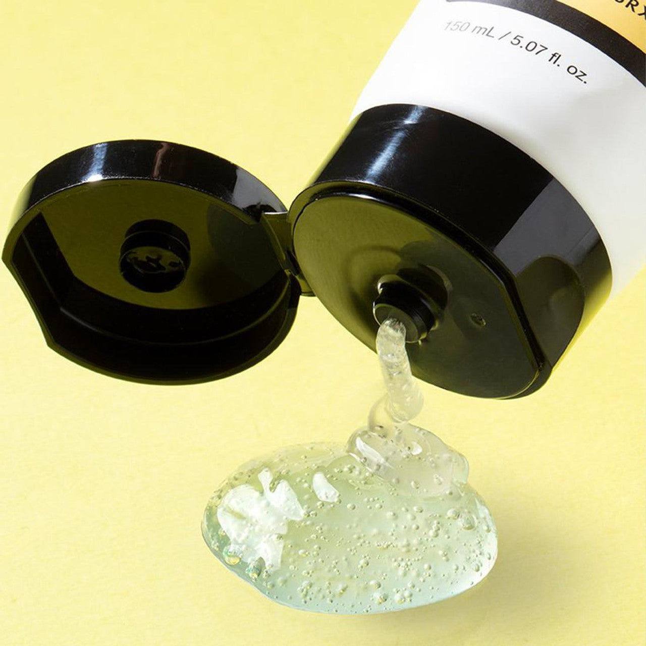 The COSRX Advanced Snail Mucin Gel Cleanser, featuring a white label and black cap, dispenses translucent bubble-filled gel enriched with snail mucin for moisture seal benefits. It comes in a 50ml tube and spreads on a light yellow surface.