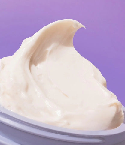 Close-up of a swirl of cream in a container with a purple background