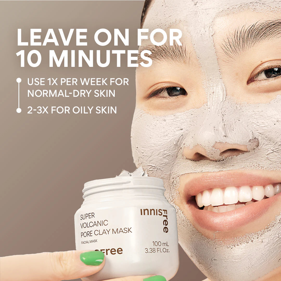 A person smiles with a clay mask on, holding a jar of INNISFREE Super Volcanic Pore Clay Mask 100ml. Use for 10 minutes to remove blackheads and control sebum. Apply once weekly for normal to dry skin, and 2-3 times for oily skin.