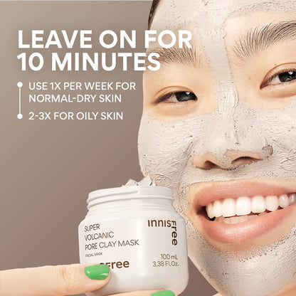 A person smiles with a clay mask on, holding a jar of INNISFREE Super Volcanic Pore Clay Mask 100ml. Use for 10 minutes to remove blackheads and control sebum. Apply once weekly for normal to dry skin, and 2-3 times for oily skin.