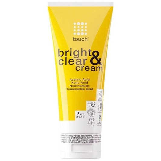 The yellow tube of Touch Bright & Clear Cream, effective for hyperpigmentation, features azelaic and kojic acids, niacinamide, and tranexamic acid. This 2 oz (56.7 g) USA-made cream includes color-correcting properties with text and safety info on the front.