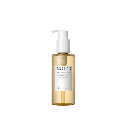 A clear plastic bottle with a white pump dispenser contains light yellow, non-comedogenic cleansing oil. The label reads SKIN1004 Madagascar Centella Light Cleansing Oil - 200ml. The design is minimalist, highlighting the purity of Centella oil from SKIN1004.