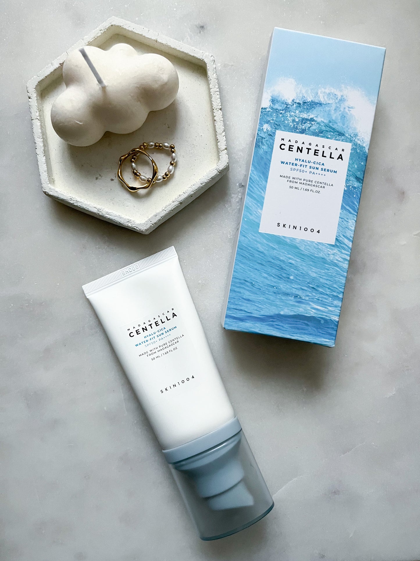 SKIN1004 Hyalu-Cica Water-Fit Sun Serum with packaging, placed on a chic vanity setup, emphasizing its lightweight, non-greasy, and hydrating SPF formula