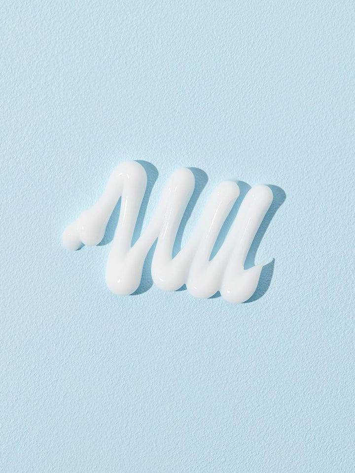 On a light blue background, the COSRX Ultimate Nourishing Rice Overnight Spa Mask features moisturising rice extract with white cream in a zigzag pattern for a truly brightening effect.